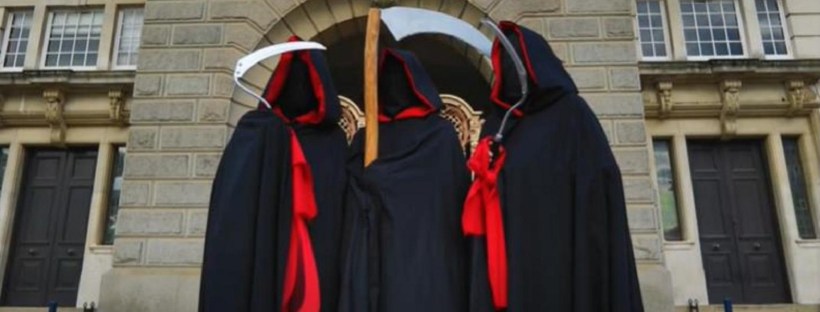 Three reapers with scythes outside KCC